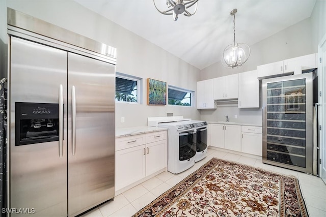 kitchen featuring electric range, stainless steel built in fridge, vaulted ceiling, and white cabinets