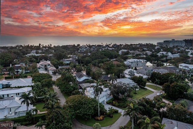 aerial view at dusk featuring a water view