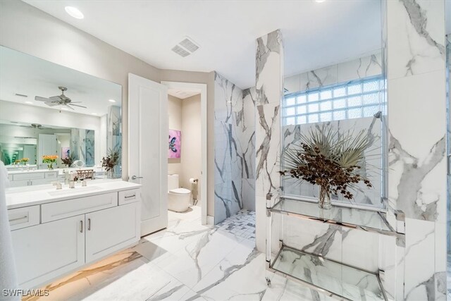 bathroom with vanity, toilet, a shower, and ceiling fan