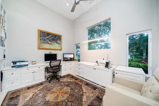 home office featuring built in desk, high vaulted ceiling, and ceiling fan