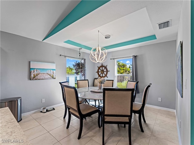 tiled dining area with an inviting chandelier, a tray ceiling, and lofted ceiling