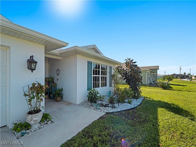 view of exterior entry featuring a yard