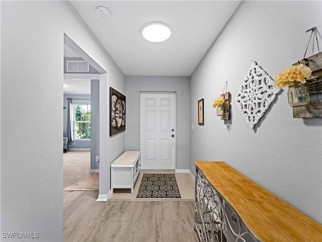 917 NW 13th Ave, Cape Coral, FL 33993 - doorway to outside featuring baseboards, light wood-style flooring, and visible vents