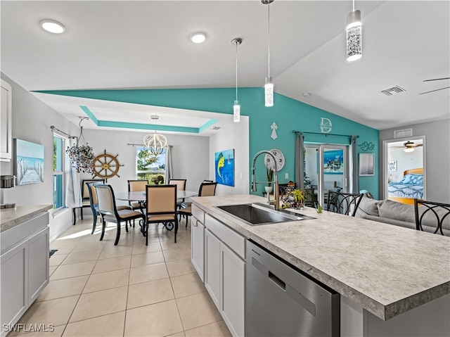 kitchen with dishwasher, lofted ceiling, sink, hanging light fixtures, and a kitchen island with sink