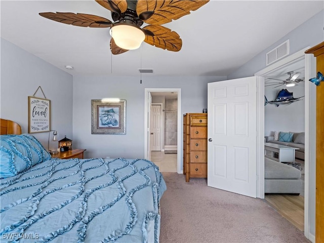 carpeted bedroom with ceiling fan and ensuite bathroom