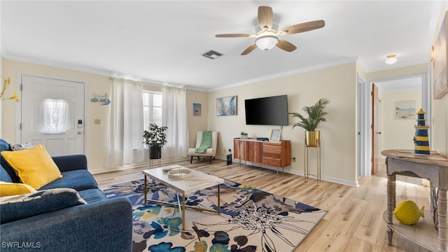 living room with crown molding, light hardwood / wood-style flooring, and ceiling fan