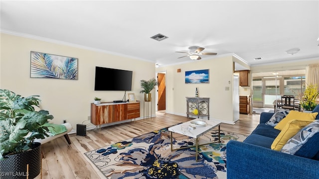 living room with ornamental molding, light wood-type flooring, and ceiling fan