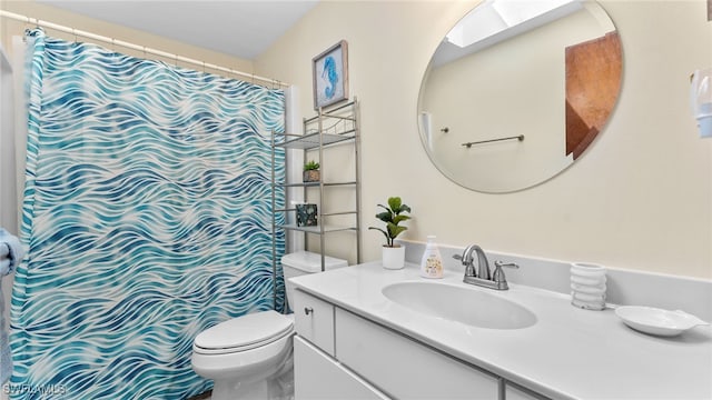 bathroom with vanity, toilet, walk in shower, and a skylight