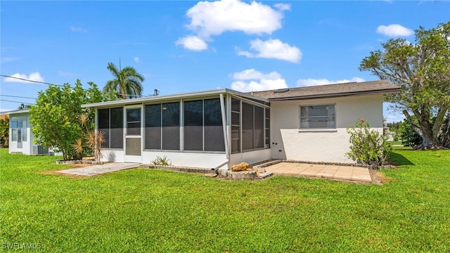 rear view of property featuring central AC, a yard, and a sunroom