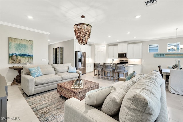 tiled living room with ornamental molding, sink, and an inviting chandelier