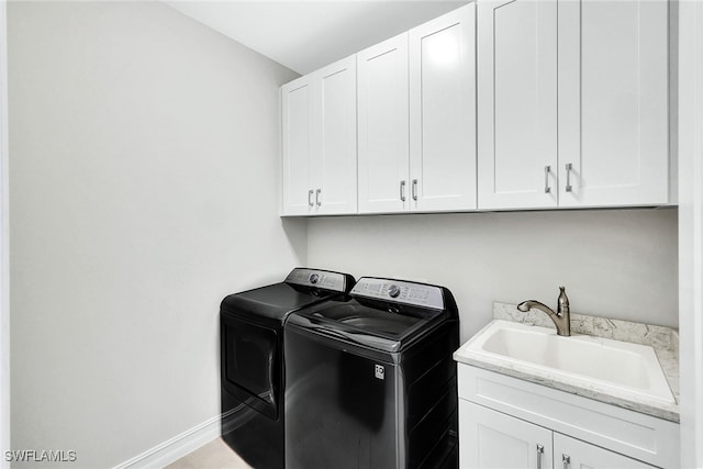 washroom featuring sink, independent washer and dryer, and cabinets