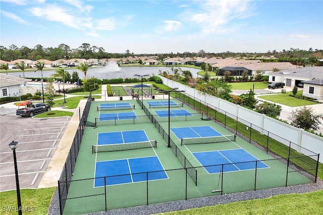 view of tennis court with a water view