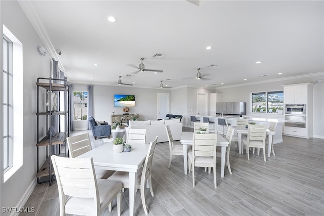 dining space featuring ceiling fan, crown molding, and light wood-type flooring