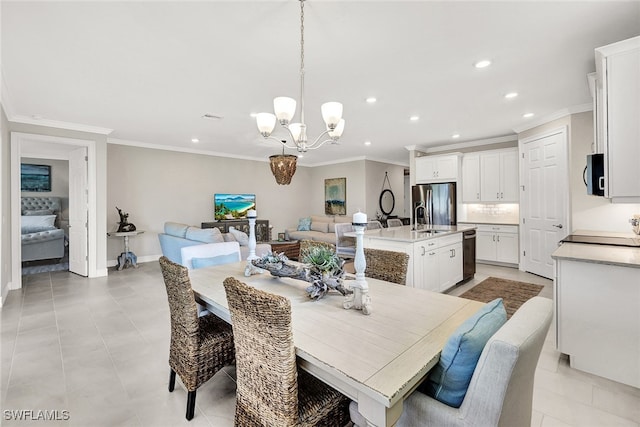 dining area with an inviting chandelier, ornamental molding, sink, and light tile patterned floors