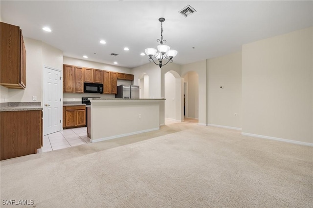 kitchen featuring hanging light fixtures, a notable chandelier, stainless steel fridge, light colored carpet, and a center island with sink