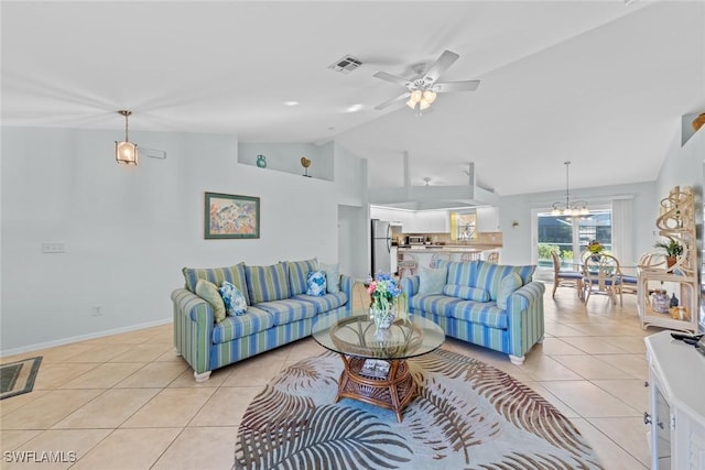 living room featuring ceiling fan with notable chandelier, light tile patterned floors, and lofted ceiling