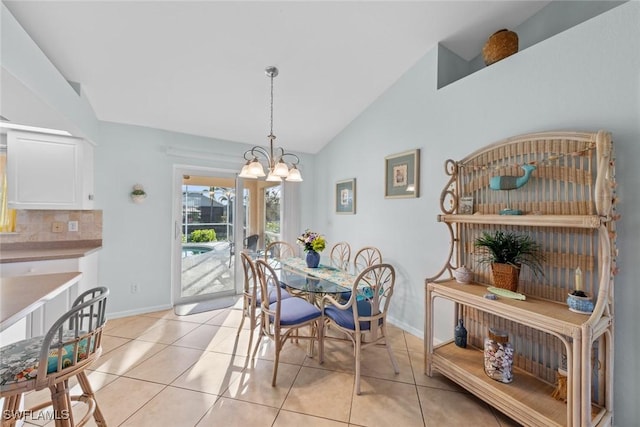 dining area with vaulted ceiling, a chandelier, and light tile patterned floors