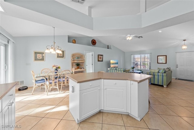 kitchen featuring decorative light fixtures, white cabinetry, a towering ceiling, light tile patterned floors, and ceiling fan with notable chandelier