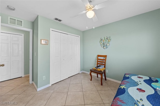 tiled bedroom with ceiling fan and a closet