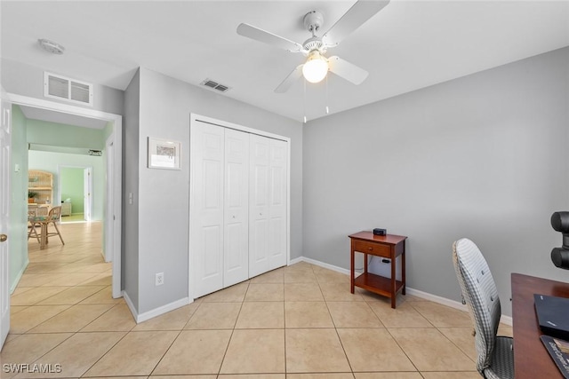 home office featuring light tile patterned floors and ceiling fan