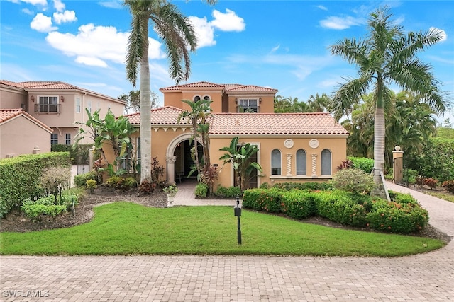 mediterranean / spanish house featuring a front lawn