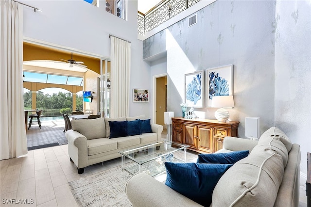 living room with a high ceiling and ceiling fan