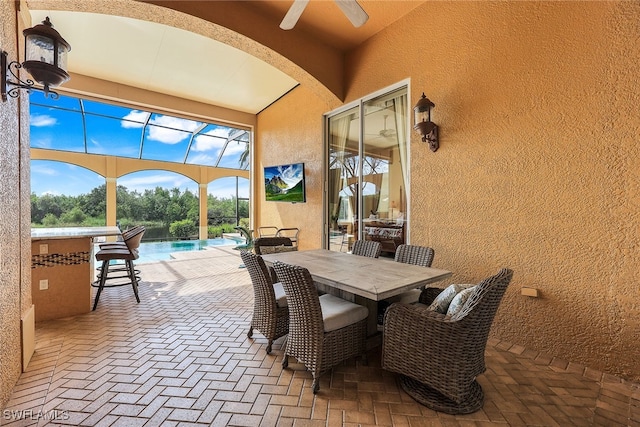 view of patio with glass enclosure and ceiling fan