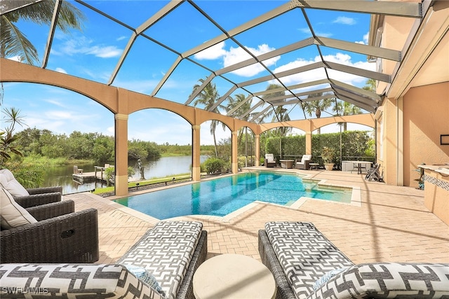 view of swimming pool with a patio, glass enclosure, and a water view