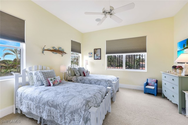 carpeted bedroom with ceiling fan and multiple windows