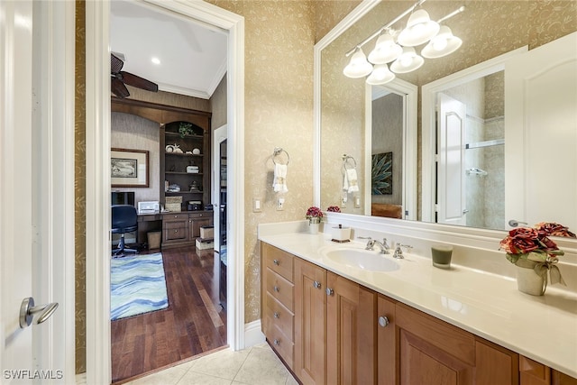 bathroom with walk in shower, hardwood / wood-style flooring, vanity, and crown molding