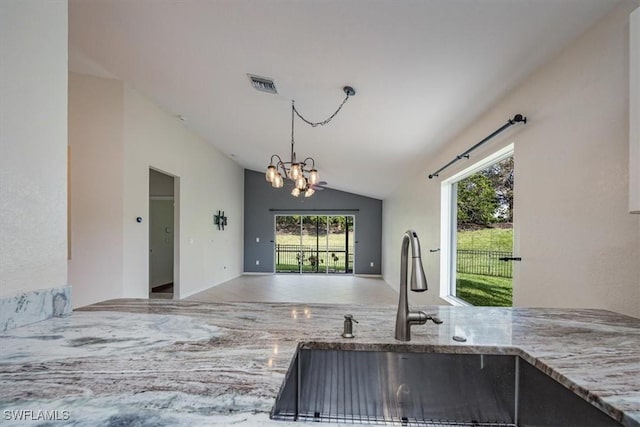 kitchen featuring lofted ceiling, a notable chandelier, hanging light fixtures, and sink