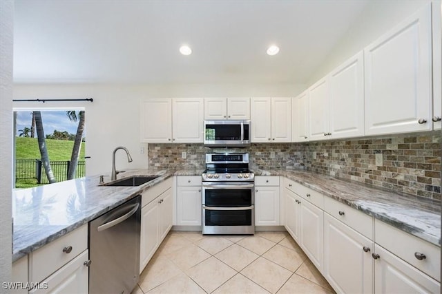 kitchen featuring sink, white cabinets, light stone countertops, and appliances with stainless steel finishes