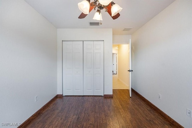 unfurnished bedroom with ceiling fan, a closet, and dark hardwood / wood-style flooring