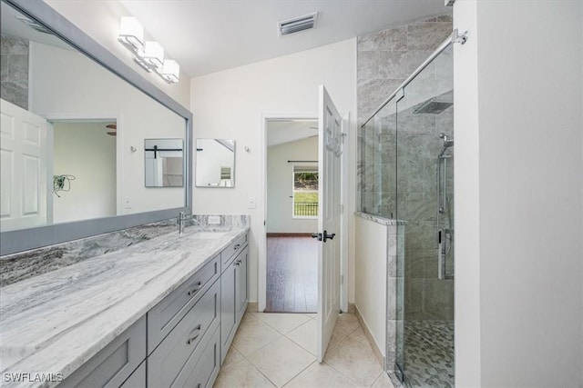 bathroom with lofted ceiling, a shower with door, tile patterned floors, and vanity