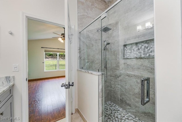 bathroom with walk in shower, tile patterned flooring, lofted ceiling, ceiling fan, and vanity