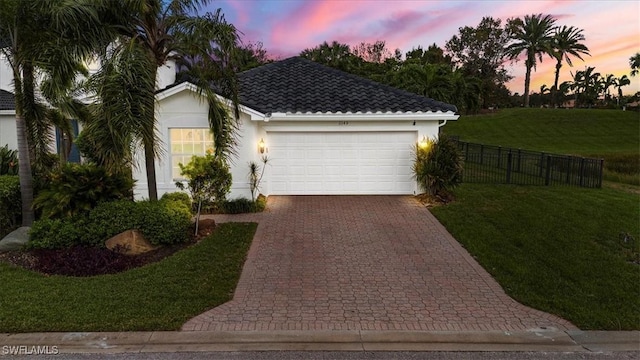 view of front facade featuring a garage and a lawn