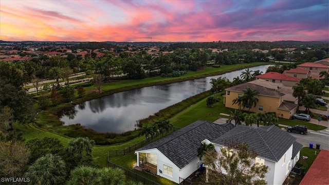 aerial view at dusk featuring a water view