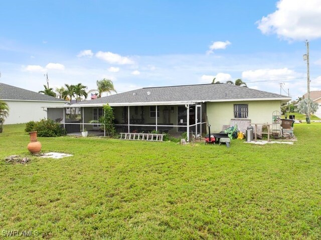 rear view of property featuring a sunroom and a yard