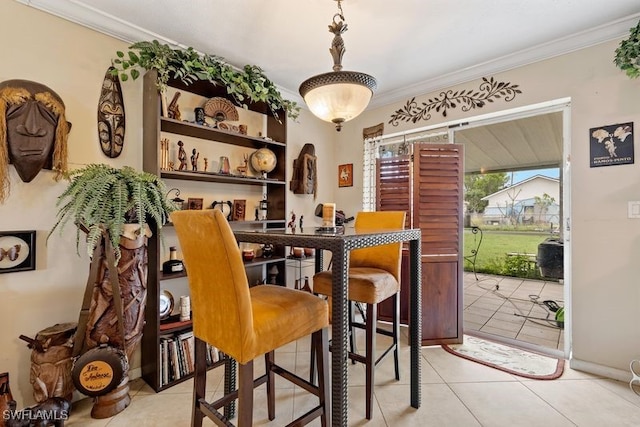 tiled dining space featuring ornamental molding