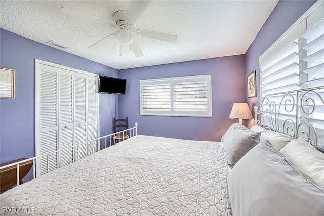 bedroom with a closet, a textured ceiling, and ceiling fan