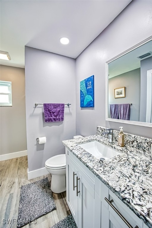 bathroom with vanity, wood-type flooring, and toilet