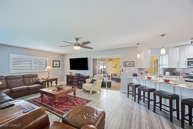 living room featuring ceiling fan and light wood-type flooring