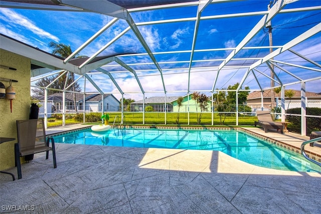 view of swimming pool featuring a lawn, a patio area, and glass enclosure