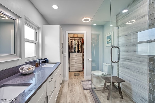 bathroom featuring vanity, toilet, hardwood / wood-style flooring, and an enclosed shower