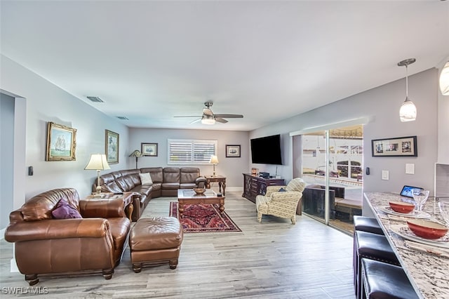 living room featuring ceiling fan and light wood-type flooring