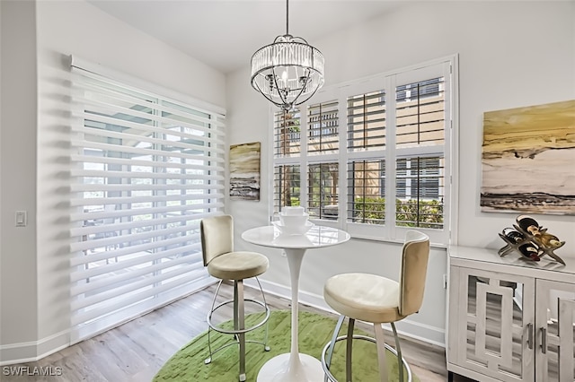 dining area with wood-type flooring, a chandelier, and a wealth of natural light