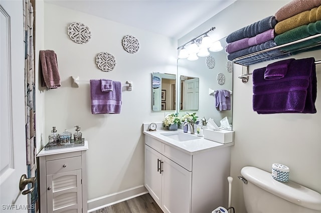 bathroom featuring toilet, vanity, and hardwood / wood-style flooring