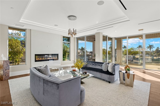 living room featuring hardwood / wood-style floors, floor to ceiling windows, and a healthy amount of sunlight