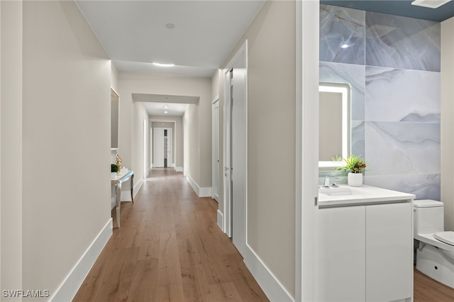 hallway featuring hardwood / wood-style flooring and sink