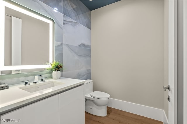 bathroom with hardwood / wood-style floors, vanity, and toilet